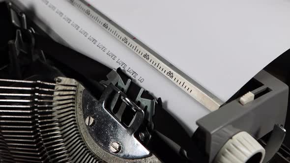 An old fashioned vintage typewriter spelling out the word Love multiple times
