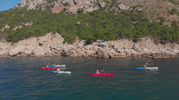 Aerial Shot Group of Kayakers Paddling Down on Mountain River on Kayaks on Summer Day