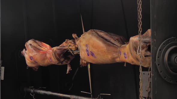 Cooking Ram Carcasses on Spit at Summer Street Food Market Slow Motion