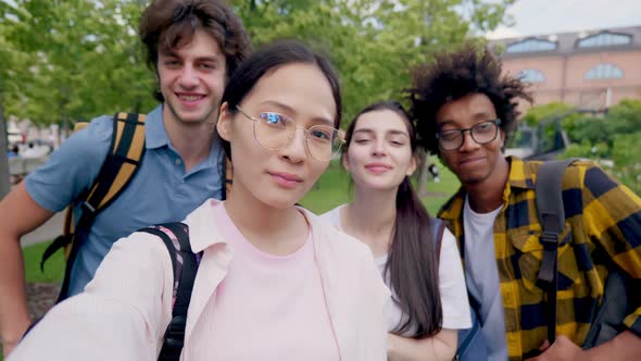 Group of Multiethnic Teen Friends Taking Selfie Outdoors and Smiling at Camera