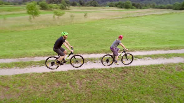 Aerial view of a couple riding a mountain bike on the forest trail in Slovenia.