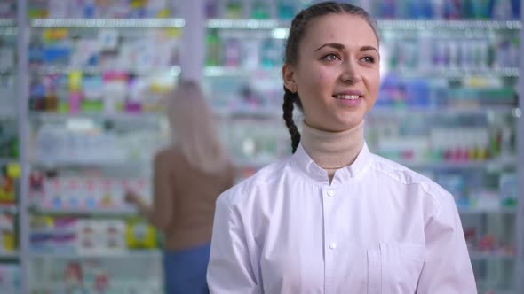 Young Smiling Beautiful Woman Standing in Drugstore Looking Around and Looking at Camera