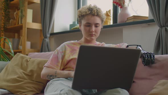 Girl with Prosthetic Arm Using Laptop at Home