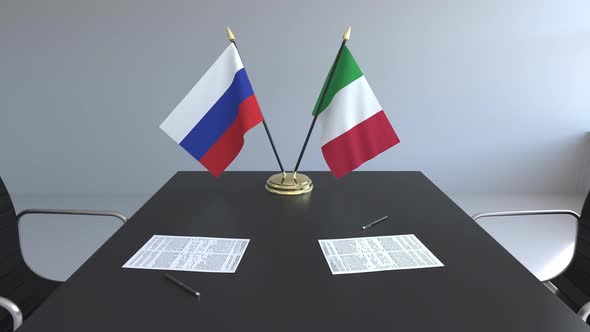 Flags of Russia and Italy and Papers on the Table