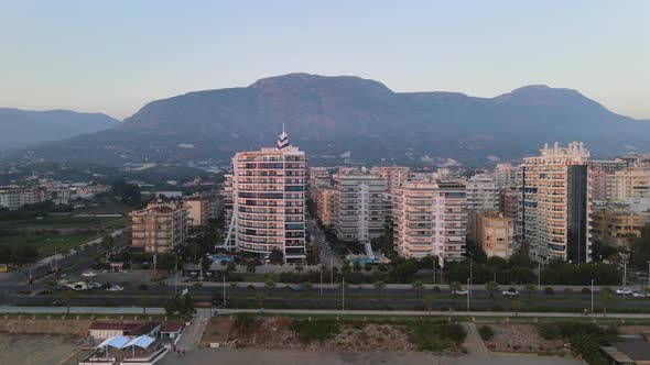 Aerial drone shot of row of residential buildings and hotels by the seaside in Alanya Turkey with th