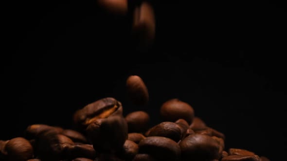 Slow motion of roasted coffee beans falling.