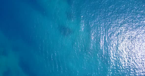 Daytime overhead tourism shot of a summer white paradise sand beach and aqua blue water background i