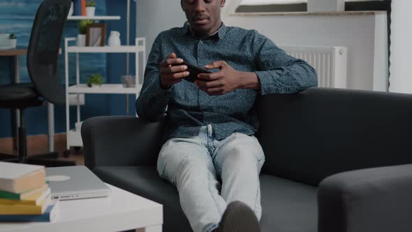 African American Man Playing Video Games on His Phone