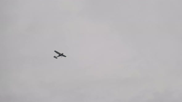 Light PropellerDriven Aircraft Flying in the Sky Among the Clouds Bottom View