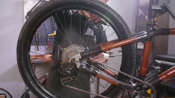 Bicycle Service Concept. A Young Man Repairs and Maintains a Bicycle in the Workshop