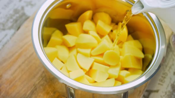 The Cook Pours Water From a Bowl Over the Boiled Potatoes