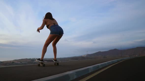 Female Skateboarders on Sunset Sky Background in Slow Motion Steadicam Shot. Ride the Mountain on