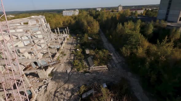 FPV Drone Flies Smoothly Among Abandoned Industrial Buildings and Around an Excavator