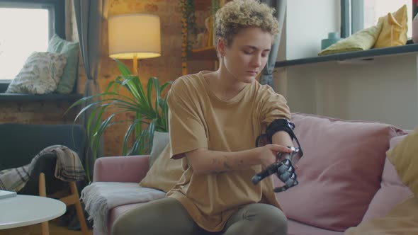 Girl Putting on Prosthetic Arm at Home