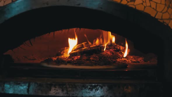 Cooking Pizza in an Italian Woodfired Clay Oven in a Restaurant