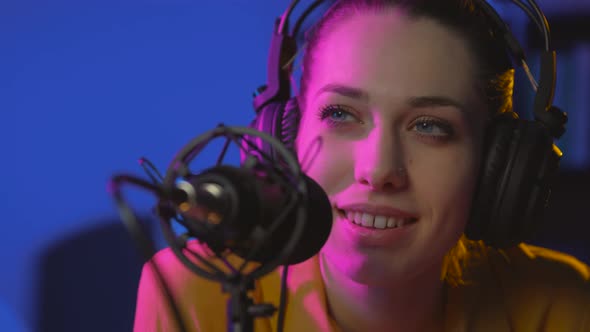 Smiling young woman working at the radio broadcasting station