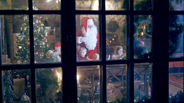 Outdoor view through the big window into the Christmas celebration. 