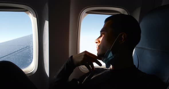 Man Passenger on the Board of Plane Using Mask Covid19 Precautions for Flight