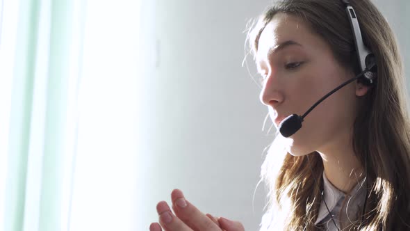 Young Woman Wearing Headphones Communicating Online Via Laptop Explaining Teaching