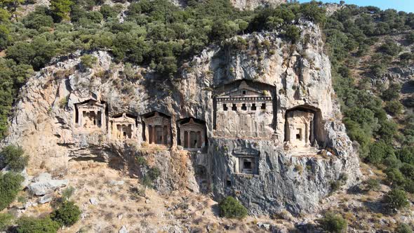 Drone shot close-up of ancient Lycian tombs carved into the rock in Turkey