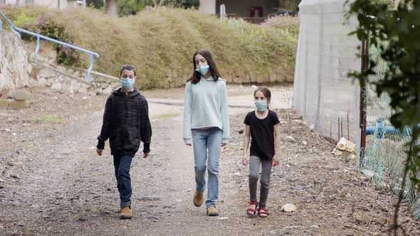 Coronavirus pandemic - kids walking outdoors with face masks to avoid contagion