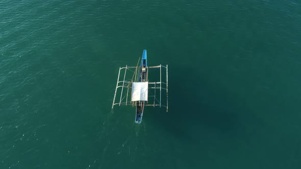 Drone View a Traditional Bangka Boat Floating in the Open Ocean on the Sunset Palawan Philippines