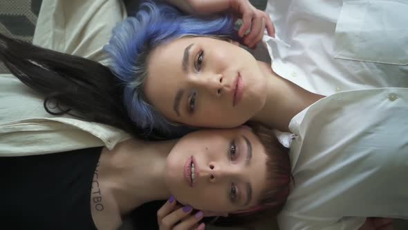 Beautiful Lesbian Women Posing for Photo Shoot Lying on Floor in Modern Interior