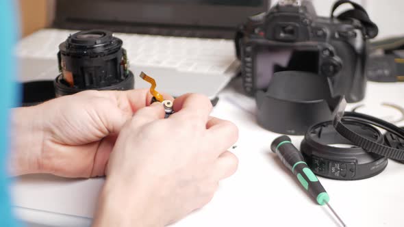 Man Repairs Camera Lens Autofocus Motor Tools