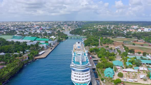 Luxury Cruise Ship Docked At Terminal In La Romana, Dominican Republic On A Sunny Day. - aerial pull