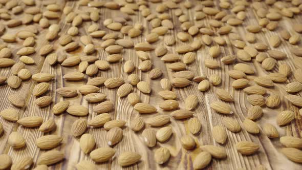 Sliding Shot of Dried Almond Lying on a Textured Wooden Table Surface