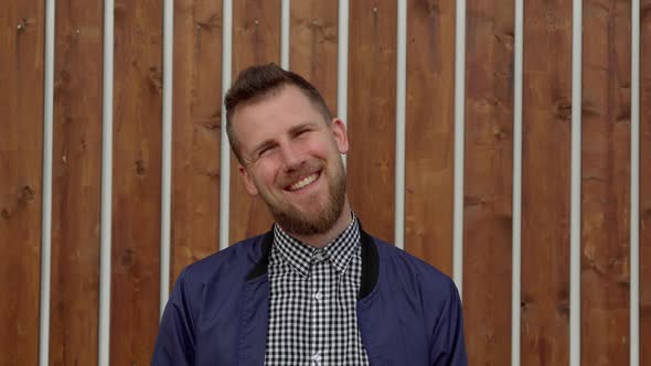 Smiling Man Against Wooden Wall