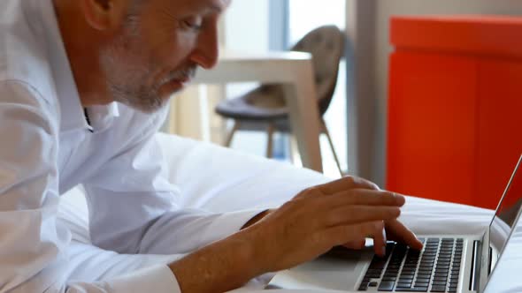 Businessman using laptop in hotel room 4k