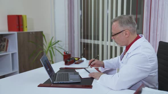 Doctor listens to a patient through the remote webcam on laptop screen