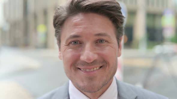 Face Close Up of Middle Aged Businessman Smiling at Camera