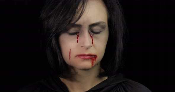 Vampire Halloween Makeup. Woman Portrait with Blood on Her Face.