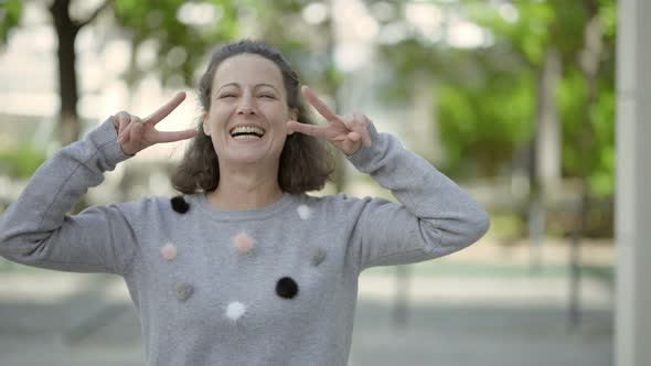 Beautiful Smiling Middle Aged Woman Showing Peace Signs