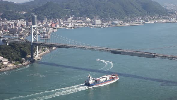 Container Ship Sailing under Big Bridge