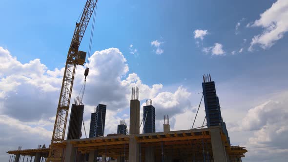 Tower Cranes and Professional Workers at High Concrete Residential Building Under Construction