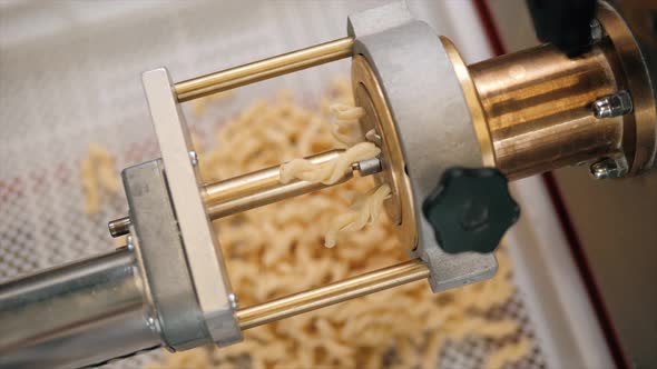 Tortiglioni Cazarece Spaghetti Pasta Falling From a Spout As They Travel Along the Production Line