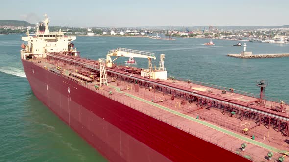 Aerial view of a red oil tanker leaves the port.