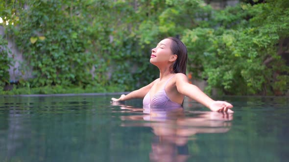 Young asian woman enjoy around outdoor swimming pool for leisure