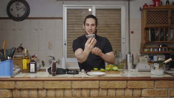 Young Barman Rims Cocktail Glass with Sugar Recording a Video Tutorial