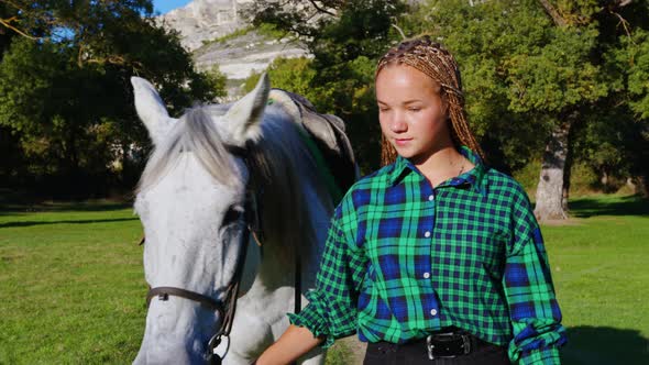 Girl with Sisterlock Leads White Horse By Reins