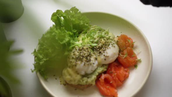 Cook Garnishes Guacamole and Poached Eggs Toast with Greenery