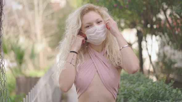 Close-up portrait of multi-race, beautiful, sexy woman putting off surgical protective mask