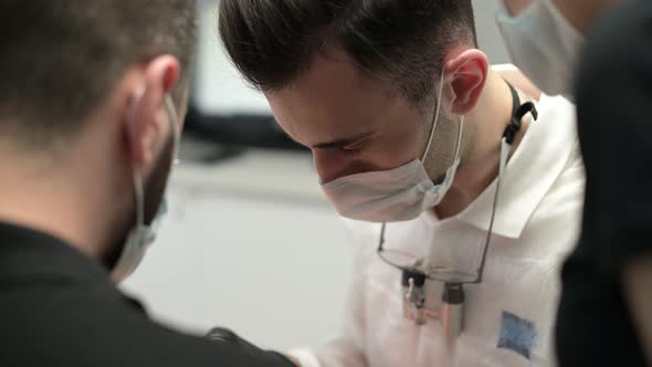 doctor, surrounded by assistants, performs an operation