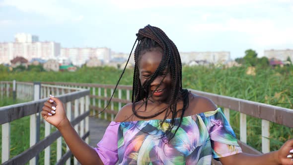 African Woman with Long Pigtails Dancing on the Bridge