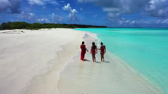 Beautiful fun women on vacation in the sun on the beach on sunny blue and white sand 4K background