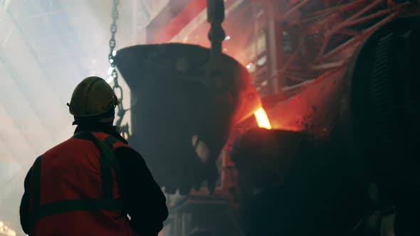 Metallurgist in Safety Wear is Watching the Steel Ladle