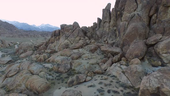 Aerial shot of a young man backpacker camping with his dog in a mountainous desert.